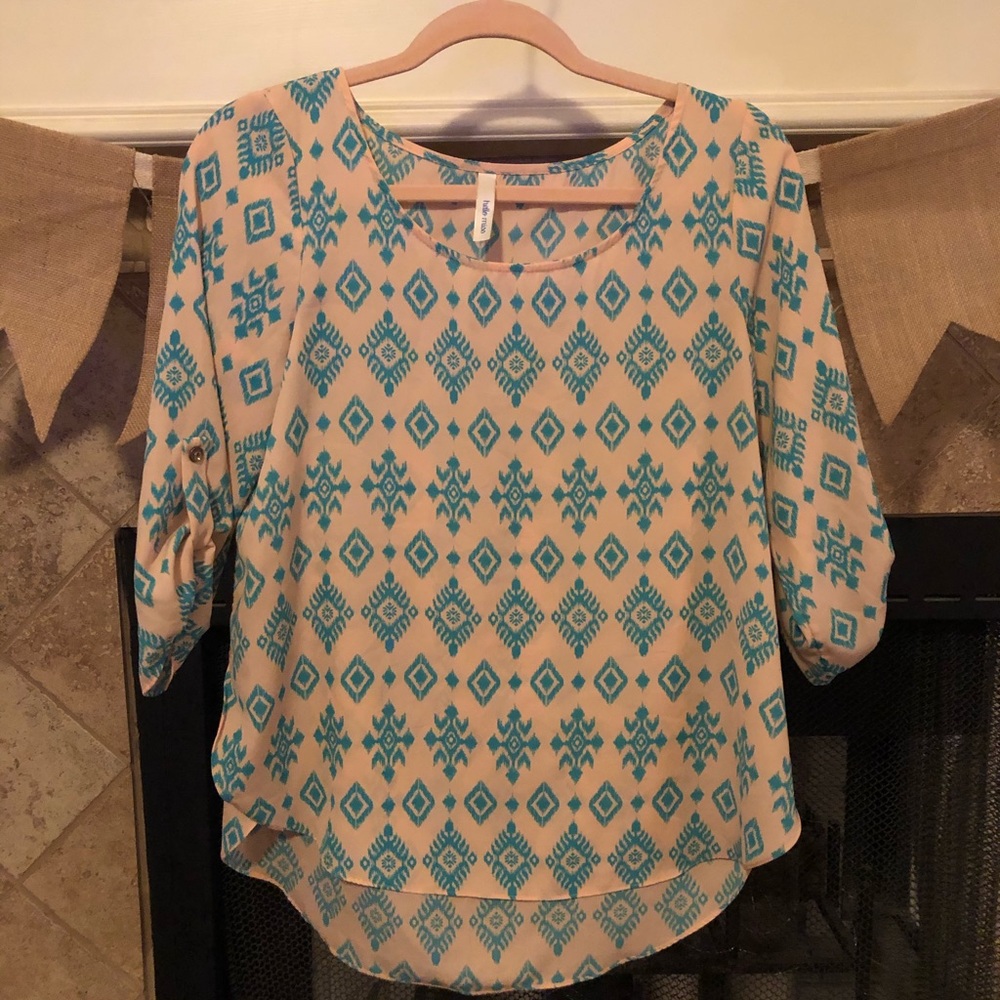 Pink blouse with blue Aztec design.